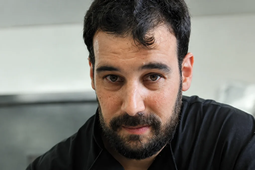 Retrato de Aitor Otin, heladero de Elarte, con chaquetilla negra en su obrador